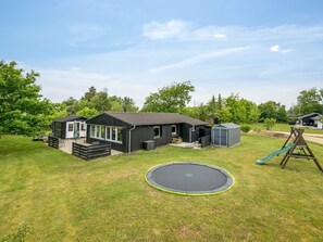 A residential property with a house, a trampoline, a play area, and a shed.