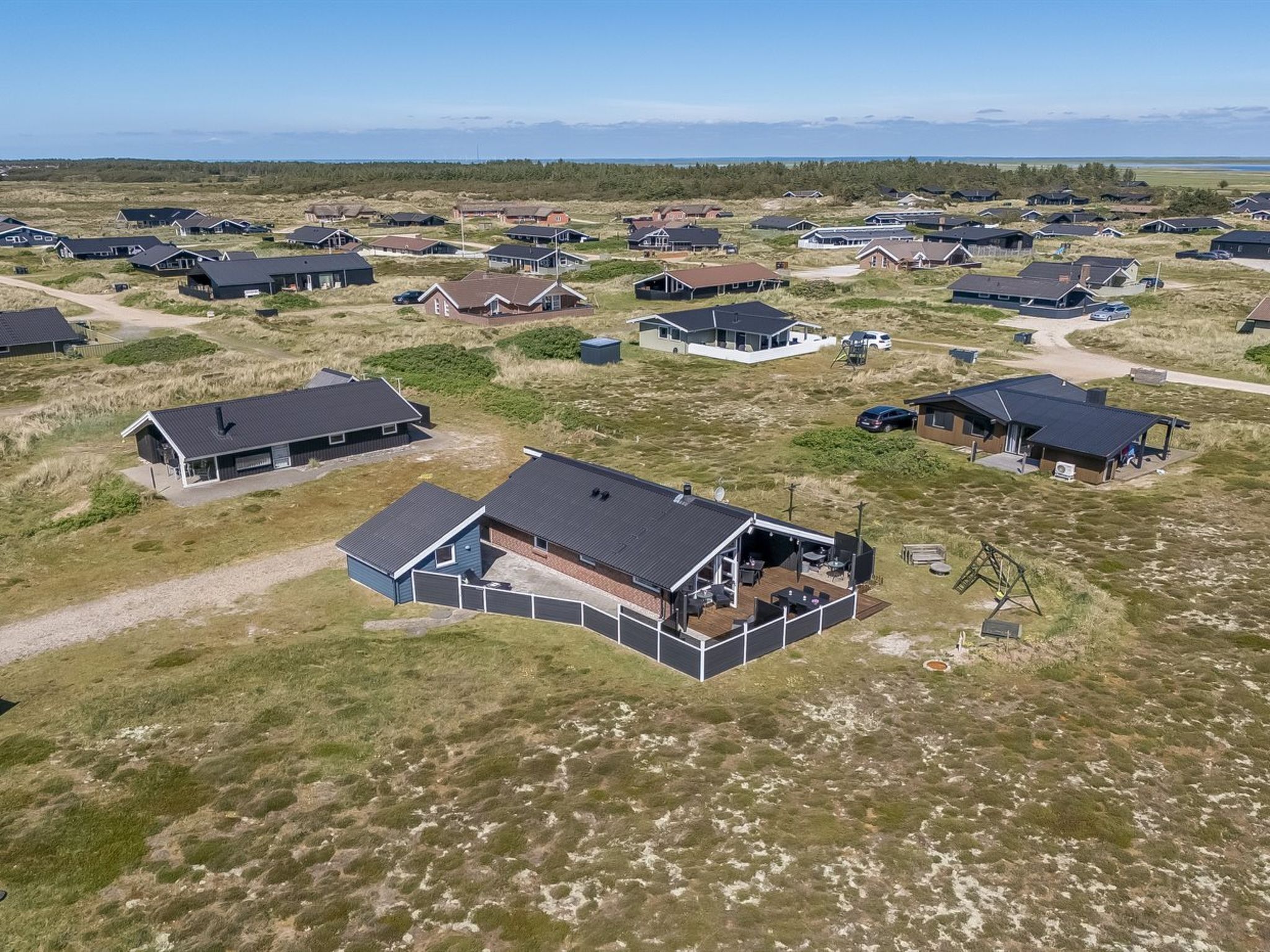 An aerial view of a residential area with multiple houses, some with attached garages and driveways.