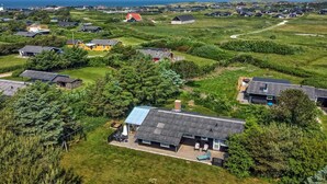 Een woonwijk met huizen, groene gazons en vrij uitzicht op zee.