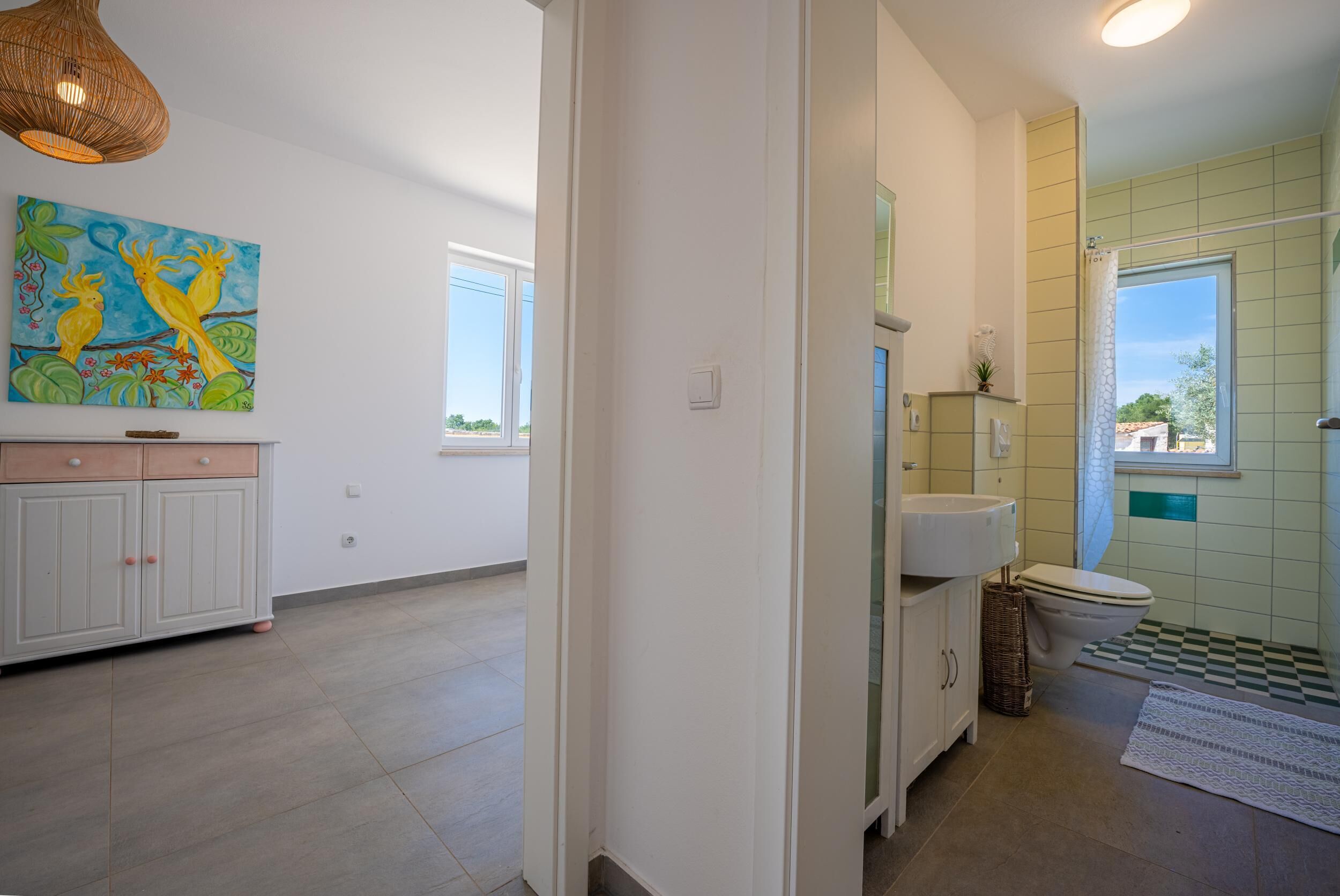Un bany ampli amb una finestra gran, un lavabo i un vàter.