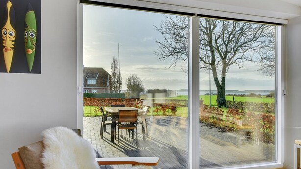 A modern room with a large sliding glass door leading to an outdoor patio.