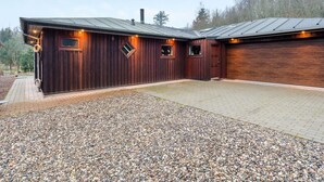 A wooden building with a gravel driveway and a metal roof.
