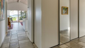 Un pasillo con una puerta corredera de vidrio que da a un balcón con vistas al exterior.