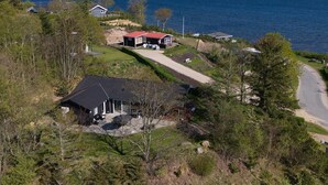 Un área residencial costera con casas, una carretera y vistas al mar.