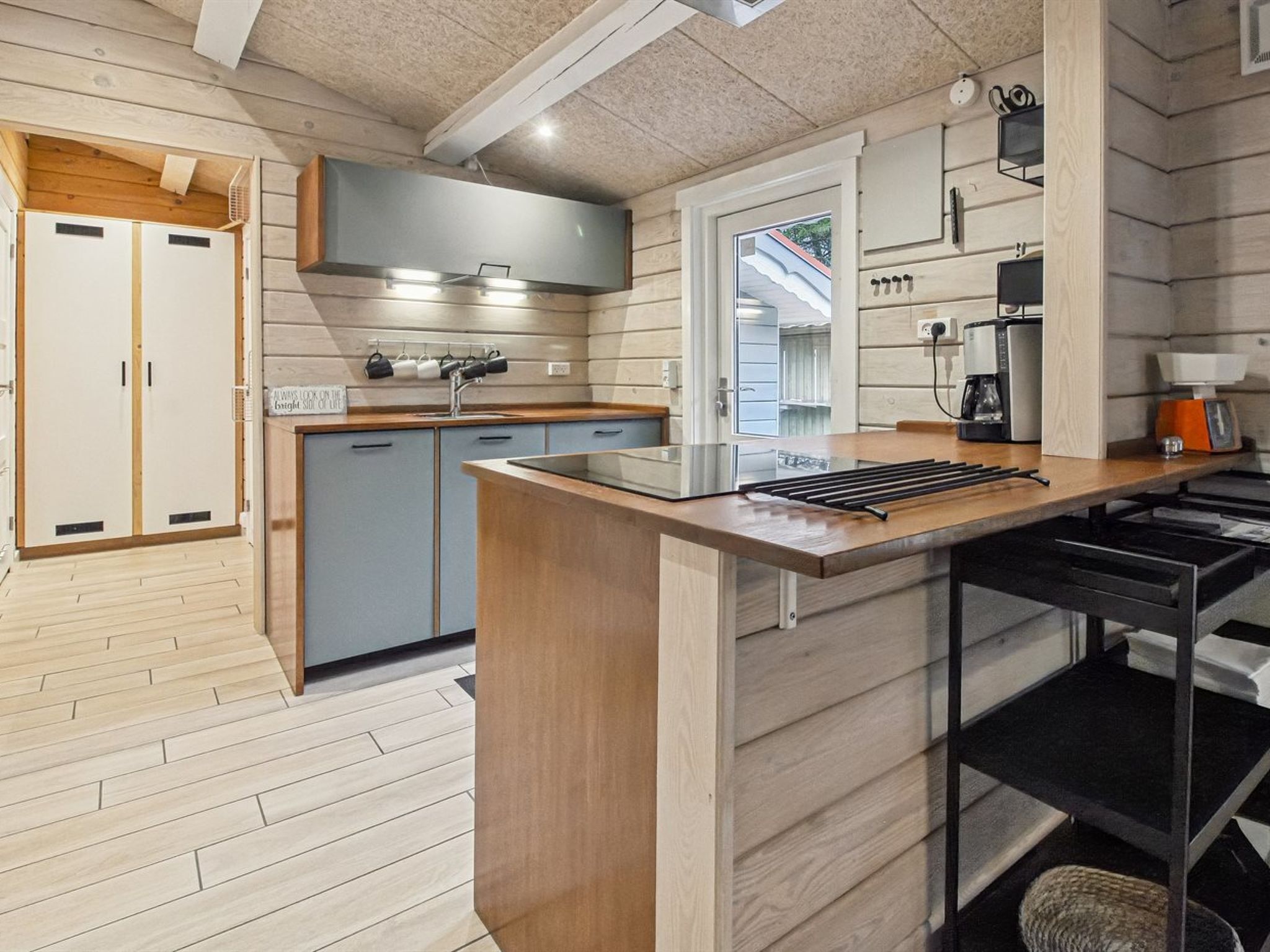 Une cuisine moderne avec des meubles en bois, un îlot central et un four encastré.