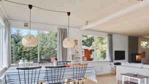 A modern living room with a dining area, large windows, and a fireplace. - "Anevay" - 300m from the sea by Interhome (Hals)