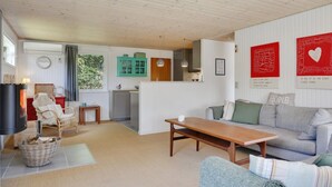 A cozy living room with a sofa, a wooden table, and a wicker basket. - "Anevay" - 300m from the sea by Interhome (Hals)