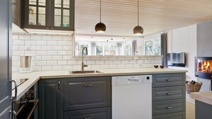 A modern kitchen with white subway tiles, dark cabinets, a dishwasher, and a built-in oven. - "Anevay" - 300m from the sea by Interhome (Hals)