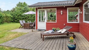 A red wooden house with a deck, a covered patio, and a lounge chair. - "Anevay" - 300m from the sea by Interhome (Hals)