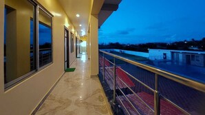 A corridor with a balcony, large windows, and a view of the sky. - Holiday Beach Resort Mandarmani (Kanthi)