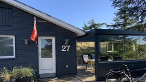 A dark-colored building with the number 27, a flag, and a bicycle parked outside. - "Gudrid" - 500m from the sea by Interhome (Fanø)