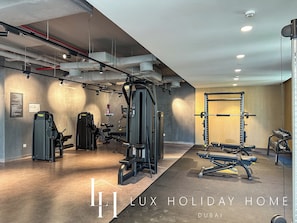 A modern gym with various exercise equipment, including a squat rack, bench press, and weight machines.
