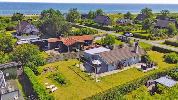 A residential area with houses, a swimming pool, and a view of the sea.