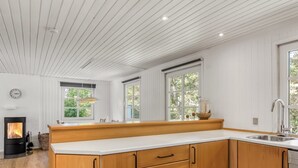 Een moderne keuken met houten kastjes, een wit aanrecht en een ingebouwde kookplaat.