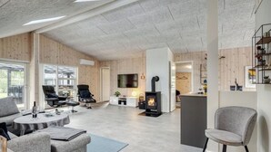A spacious living area with a fireplace, comfortable seating, and a large TV.