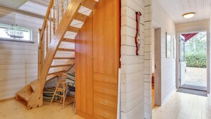 Un escalier en bois menant à une mezzanine, avec une porte en bois et une petite échelle.