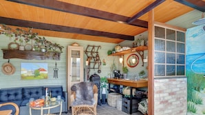 A cozy interior with a blue sofa, wicker chair, and a stone-tiled floor. - "Fido" - 300m from the sea by Interhome (Hals)