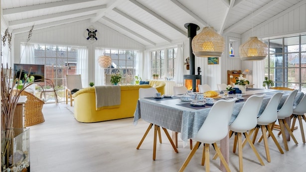 A spacious room with a high ceiling, a yellow sofa, a dining table with chairs, and a large window. - "Fido" - 300m from the sea by Interhome (Hals)