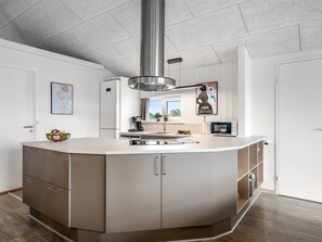 A modern kitchen with a central island, built-in appliances, and a large window. - "Alli" - 800m from the sea by Interhome (Fanø)