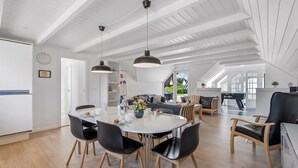 A spacious dining area with a round table, black chairs, and pendant lighting. - "Lidija" - 850m from the sea by Interhome (Ringkøbing)