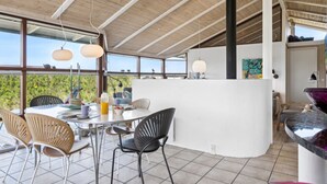 Eine moderne Küche mit Kochinsel, großen Fenstern und hoher Decke.