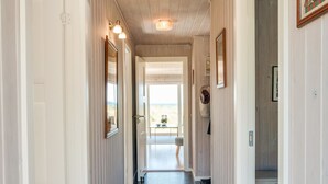 A hallway with white walls and wooden paneling, leading to a balcony with a view of the beach. - "Diuri" - 400m from the sea by Interhome (Saltum)