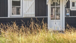 A black wooden building with white trim and a number '3' on the door. - "Idunn" - 100m to the fjord by Interhome (Vestervig)