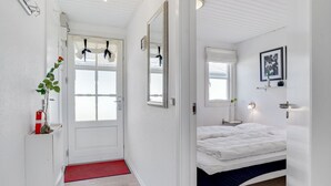 A bedroom with a bed, a bedside table, a mirror, a window, and a door. - "Idunn" - 100m to the fjord by Interhome (Vestervig)