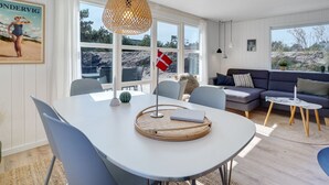 A modern living room with a dining area, large windows, and a view of the beach. - "Gillis" - 900m from the sea by Interhome (Ringkøbing)
