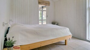 Ein Schlafzimmer mit einem Holzbett, einem Fenster mit Blick und einer Heizung.
