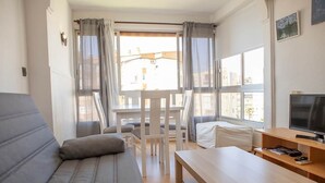 A modern living room with a sofa, a dining table, a TV, and large windows. - Apartment With see View in Algarrobo. 20 Meters to the Beach (Algarrobo - Costa)