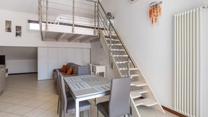Eine moderne Wohnung mit Schlafgalerie, Essbereich und Küche.