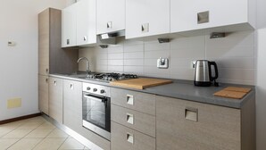 Eine moderne Küche mit Gasherd, Backofen und Edelstahlgeräten.
