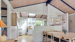 A spacious kitchen with white cabinetry, a wooden dining table, and a blue rug. - "Heike" - 1.3km from the sea by Interhome (Blokhus)