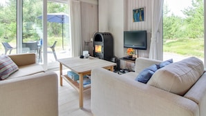 A cozy living room with a fireplace, a television, and a comfortable seating area with a table. - "Heike" - 1.3km from the sea by Interhome (Blokhus)