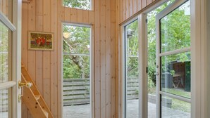 Een houten interieur met een trap die leidt naar een glazen deur.