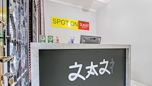 A reception desk with a sign that reads "SPOTON" and a sign with Japanese characters. - OYO Life 92575 Zazi Homestay (Depok)