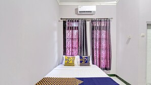 A hotel room with a bed, air conditioning unit, curtains, and a window. - OYO Life 92575 Zazi Homestay (Depok)