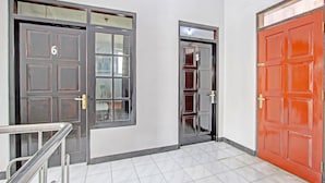 A hallway with three doors, each marked with a number. - OYO Life 92575 Zazi Homestay (Depok)