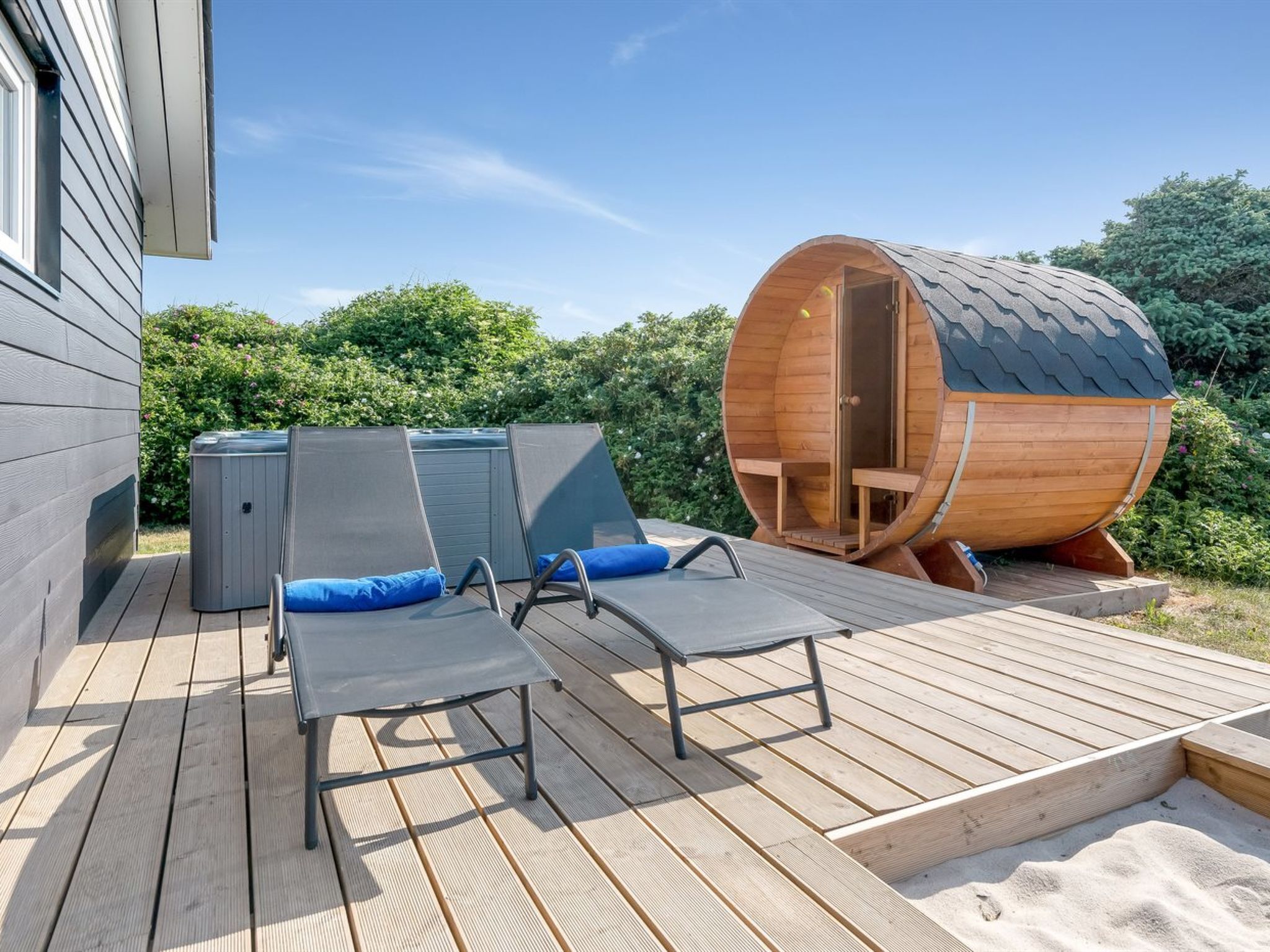 Eine Terrasse mit zwei Liegestühlen und einem Whirlpool.