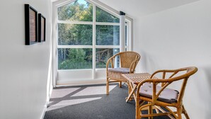 A room with a large window, two wicker chairs, and a small table. - "Kringfod" - 590m from the sea by Interhome (Hals)