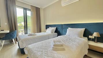 A hotel room with two beds, a desk, and a chair.
