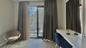 A modern room with a balcony, a desk, a chair, and a large mirror. - Comfort Apartments Pasha  (Budva)