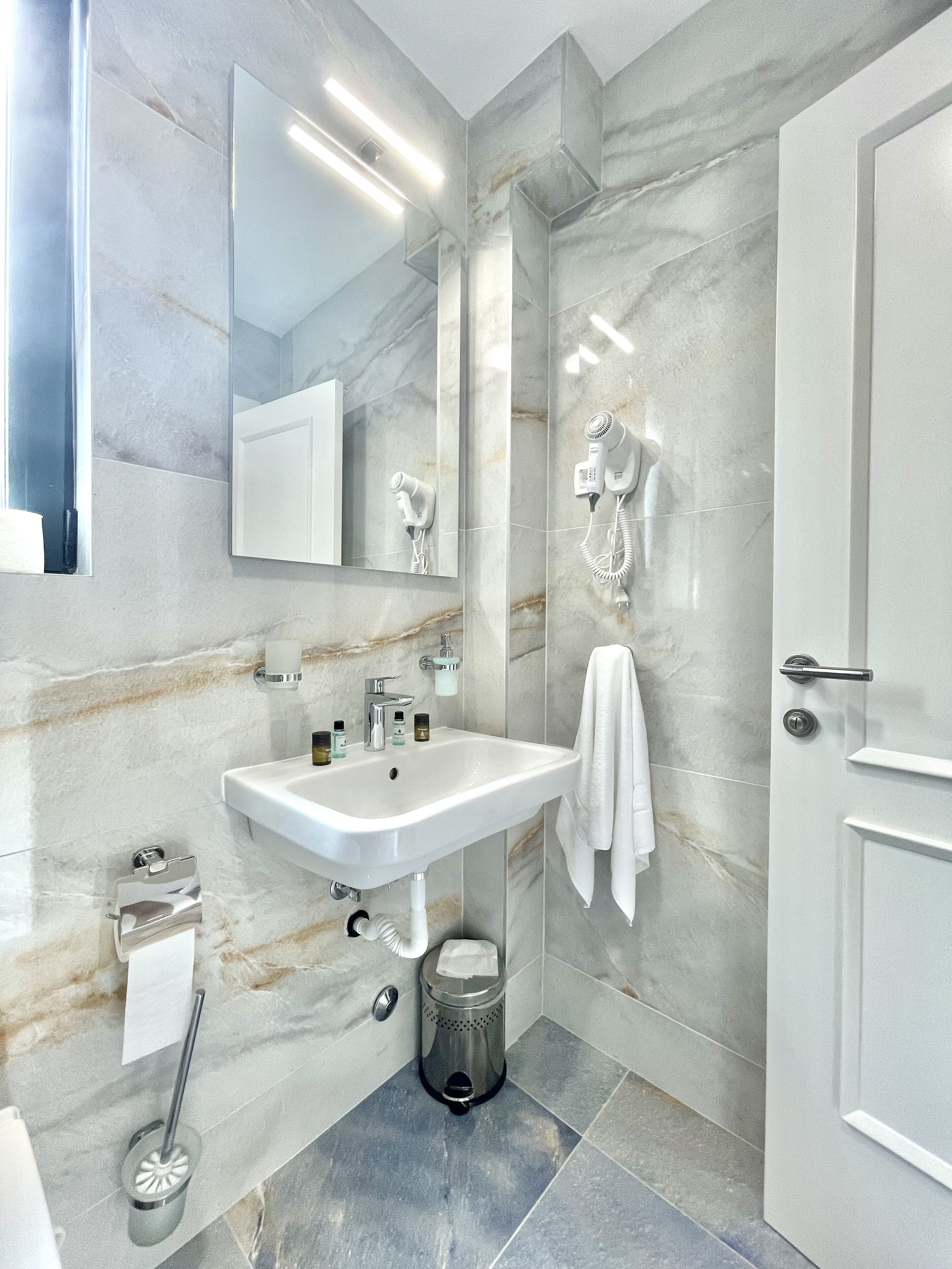 Ein modernes Badezimmer mit Waschbecken, Spiegel und Handtuchhalter.
