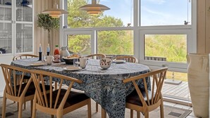 A dining area with a round table, chairs, and pendant lights.