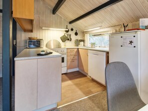 A compact kitchen with a microwave, stove, and refrigerator. - "Rentje" - 31km from the sea by Interhome (Toftlund)