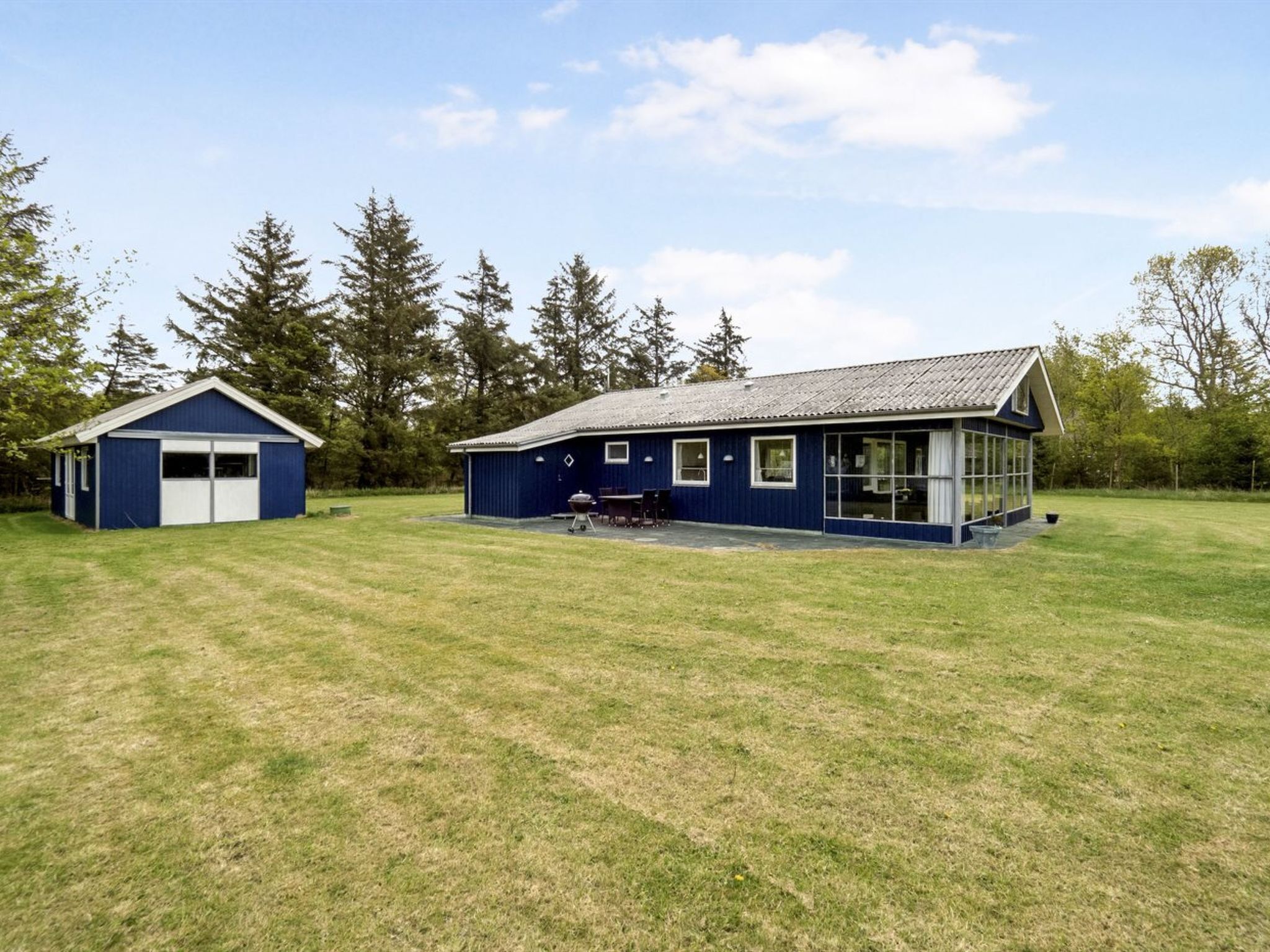 A blue building with a garage and a covered patio area.