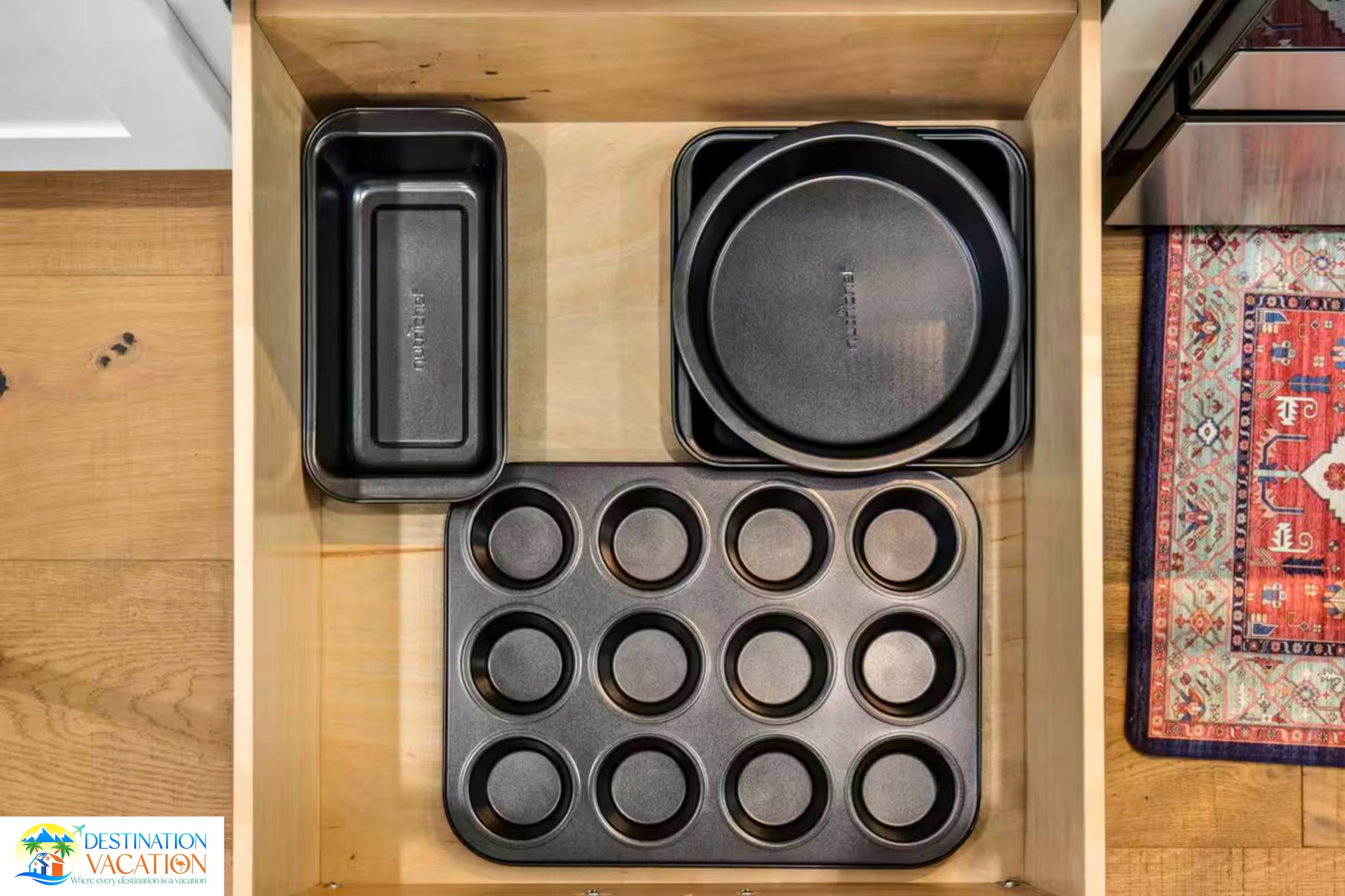 Un cajón de cocina con bandejas para hornear y un molde para muffins.