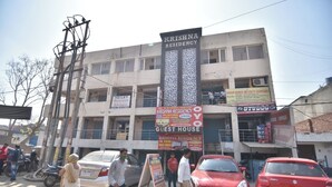 Ein Gebäude mit mehreren Schildern, die Gästehäuser Krishna Residency bewerben.