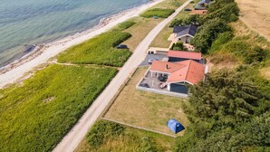 An aerial view of a coastal property with a row of houses along the beach, a clear path leading to the beach, and a tent set up on the property. - "Akseline" - 20m from the sea by Interhome (Assens)